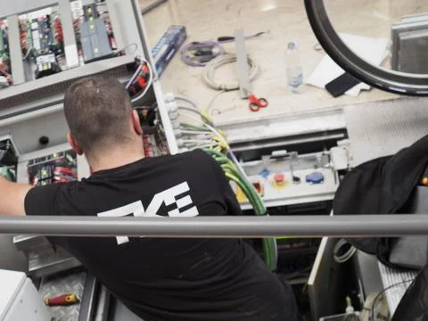 Technician performing maintenance installing new wiring on an industrial el.. Stock Photos