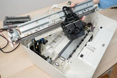 Technician performing maintenance on an open inkjet printer, removing and ins Stock Photos