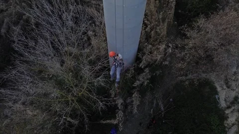 Technician performing rope access inspection on industrial column Stock Footage 306669582