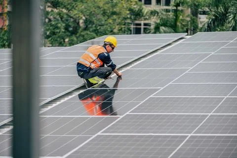 Technician performs maintenance on solar panels at a renewable energy insta.. Stock Photos