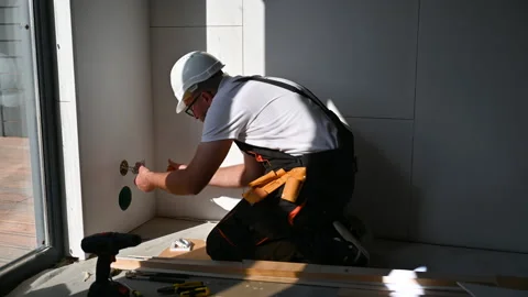 Technician performs socket installation on unfinished wall. Close shot of Stock Footage 346768056