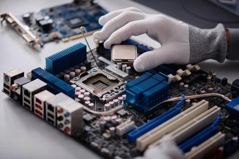 Technician Placing CPU on Computer Mainboard 库存照片