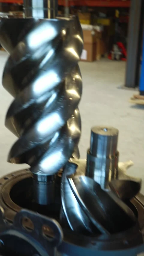 Technician placing screw compressor rotor into housing Stock Footage 314210260