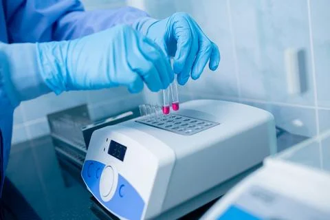 Technician placing test tubes into a dry block incubator for medical diagno.. Stock Photos