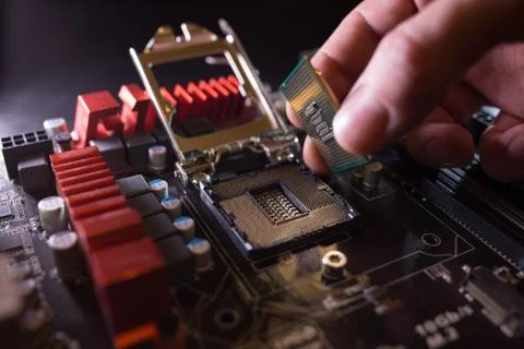 Technician plug in CPU microprocessor to motherboard socket. Workshop background 写真素材