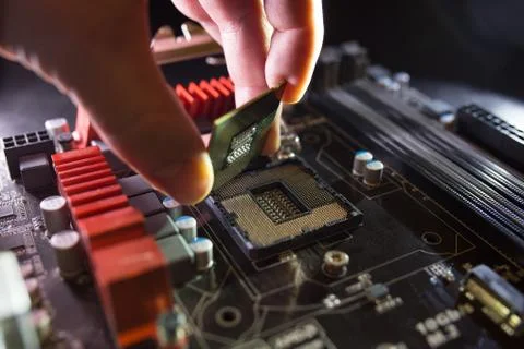 Technician plug in CPU microprocessor to motherboard socket. Workshop background 스톡 사진