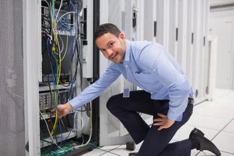 Technician plugging cable into server Stock Photos