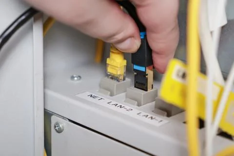 Technician plugging ethernet cable into network switch, close-up of interne.. Stock Photos