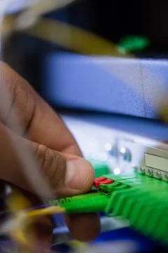 Technician plugging patch cable in a rack mounted server Stock Photos