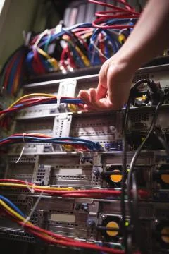 Technician plugging patch cable in a rack mounted server Stock Photos