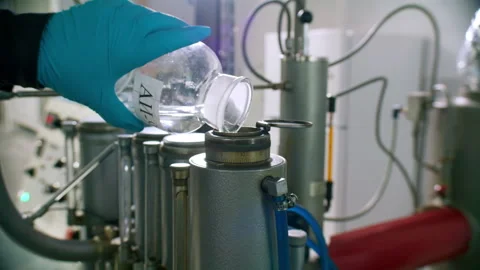 Technician pours liquid from bottle into stainless tank Stock-Footage 326001436