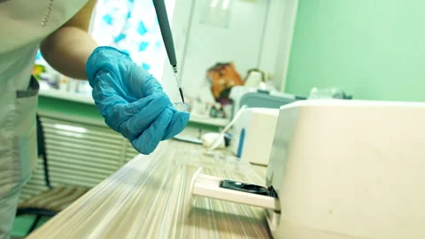Technician precisely places sample onto analytical instrument Stock Footage 333989380