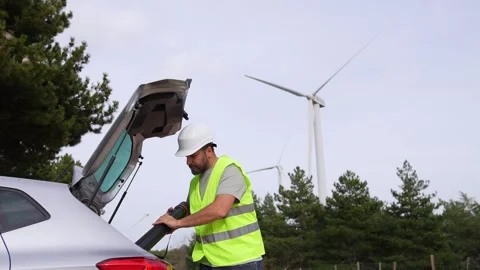 Technician Preparing for Work Next to Car in Wind Turbine Field Stock Footage 276312453