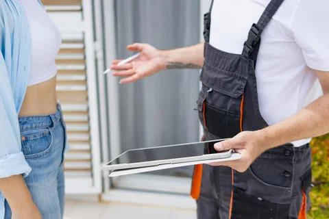 Technician presenting digital service contract to client on tablet, discuss.. 스톡 사진