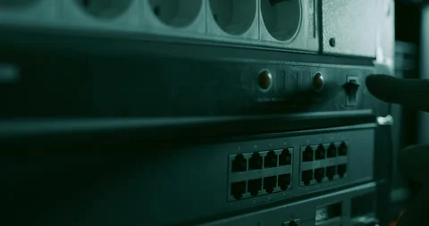 Technician presses the "turn on" button on a network switch Stock Footage 131016732