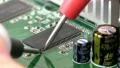 Technician probes circuit board; 3 HD Footage