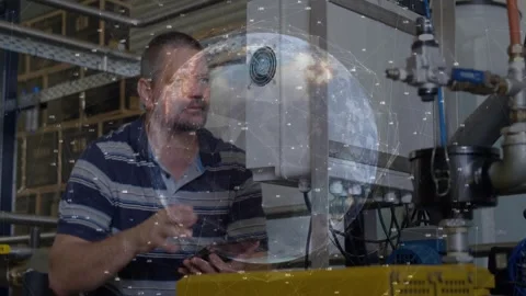 Technician probing control box after alarm in plant, logging data on tablet with Stock Footage 332522796