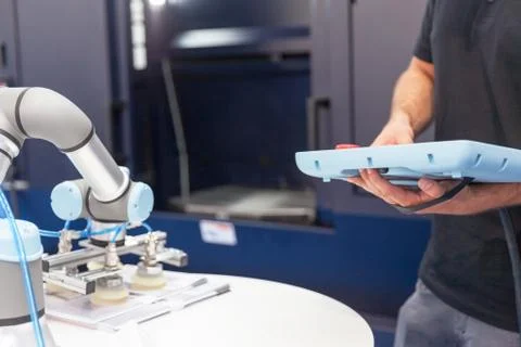 Technician programming and operating the robotic arm Stock Photos