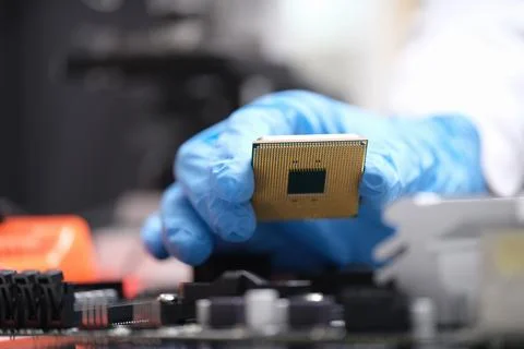 Technician puts processor on computer motherboard socket Stock Photos