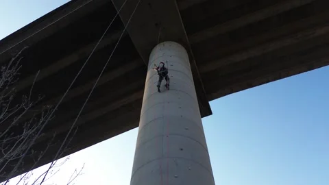 Technician rappelling down bridge pillar for inspection Stock Footage 307312188