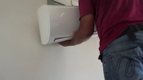 Technician removing air conditioner from wall for cleaning Stock Footage 130893292