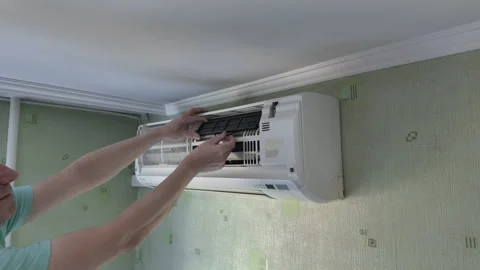 Technician removing air filter frame from split system air conditioner duri.. 库存影片 341410049