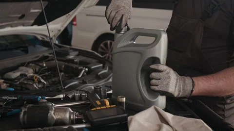 Technician Removing Cap from Canister to Change Engine Oil on Car in Garage Stock Footage 329404762
