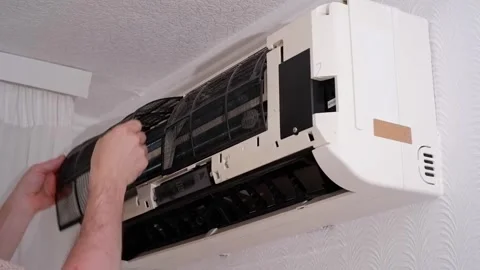 Technician removing dirty filter from air conditioner unit Stock Footage 338008543