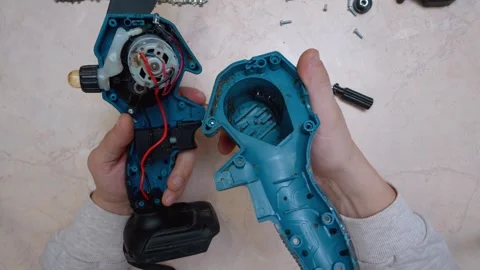 Technician repairing and disassembling cordless electric chainsaw Stock Footage 326146582