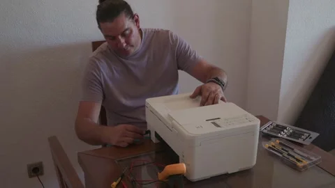 Technician repairing a broken printer at home Stock Footage 336950644