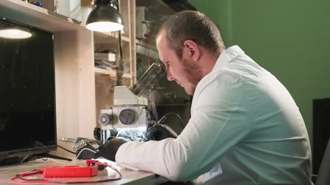 Technician Repairing Circuit Board Under Microscope in Tech Workshop Stock Footage 282301551