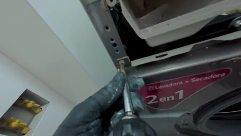 Technician repairing washing machine with screwdriver Stock Footage 328385302
