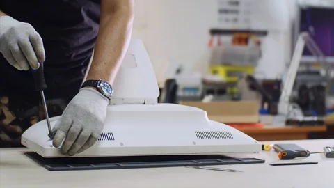 Technician repairs and diagnostics computer monoblock unscrew bolts in workshop. Stock Footage 114609630
