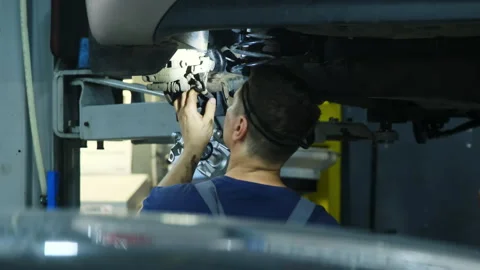 Technician repairs brake system standing underneath car Stock Footage 317629857