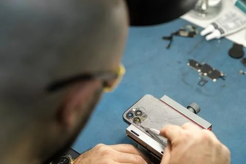 Technician Repairs Broken Smartphone Screen at a Repair Workshop in the Stock Photos