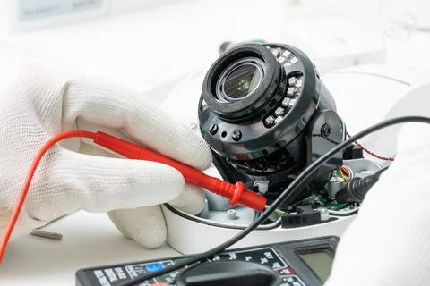 Technician repairs CCTV camera on the table. close-up. Stock Photos