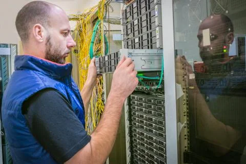 Technician repairs the central router. System administrator installs a new se Stock Photos
