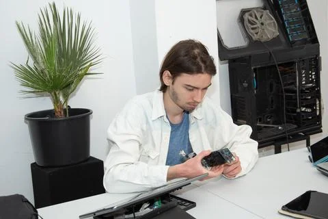 A technician repairs computer equipment using electronic components and tools Stock Photos
