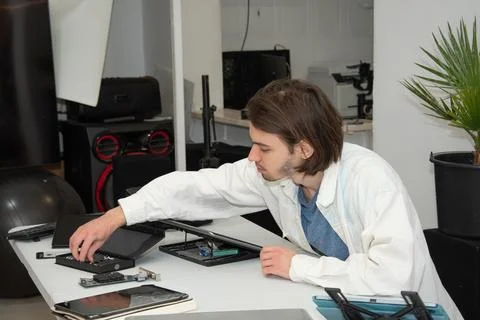 A technician repairs computer equipment using electronic components and tools Foto stock