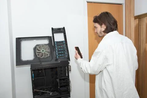 A technician repairs computer equipment using electronic components and tools Stock Photos