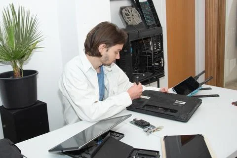 A technician repairs computer equipment using electronic components and tools Stock Photos