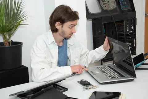 A technician repairs computer equipment using electronic components and tools Foto stock