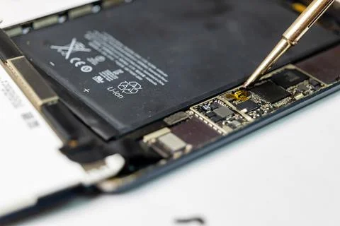 Technician Repairs Damaged Tablet with Precision Tools Stock Photos