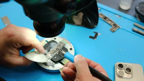 Technician repairs electronic device under microscope, using tools and Stock Footage 339701010