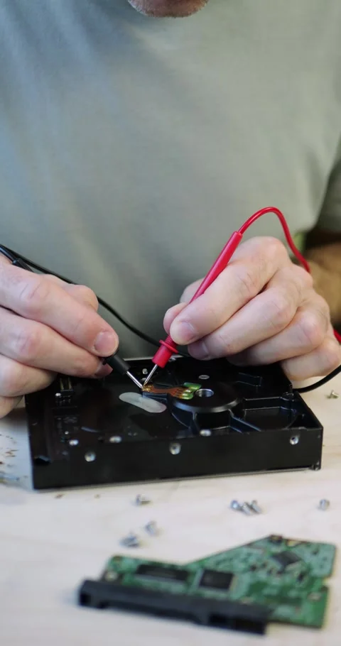 Technician repairs hard drive using precision tools at electronics workstation Stock Footage 348486861