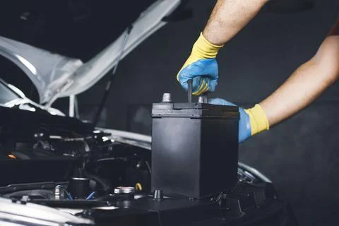 Technician replace car old battery Fotos de archivo