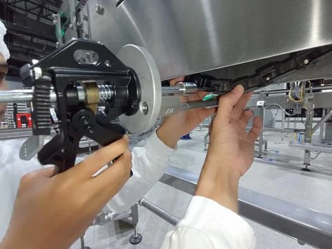 A technician is replacing a broken plastic conveyor with a new one Foto stock