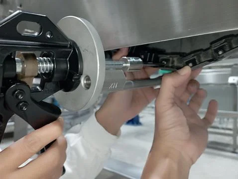 A technician is replacing a broken plastic conveyor with a new one Foto stock