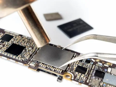 Technician replacing flash storage of smartphone motherboard Stock Photos
