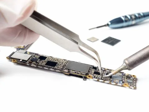 Technician replacing microchip of smartphone logic board Stock Photos